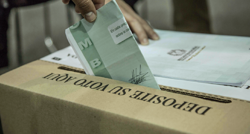 mano depositando un voto en elecciones