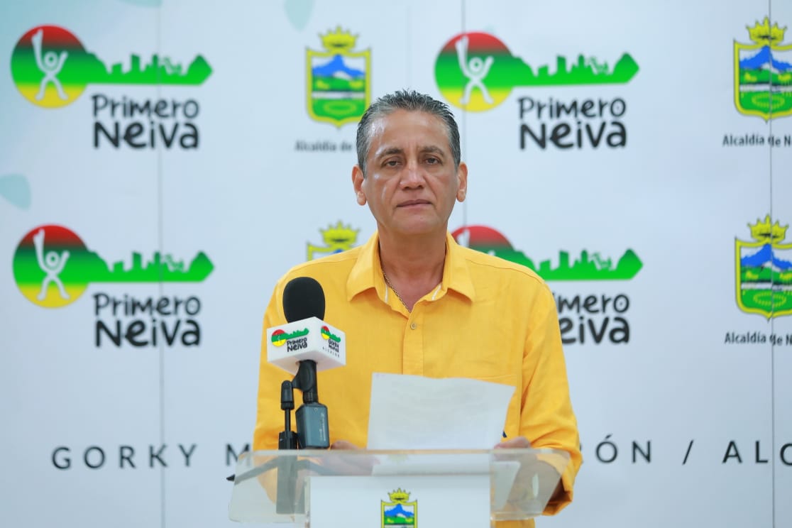 persona vestida de camisa amarilla, en frente de un backing