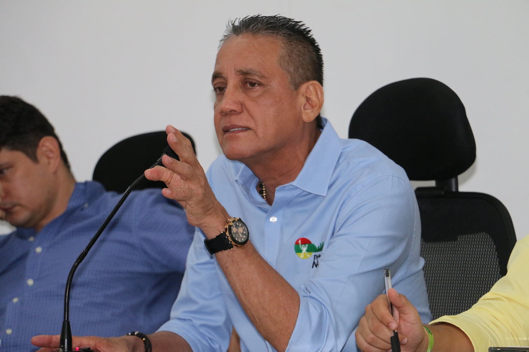 persona sentada, con una mano alzada